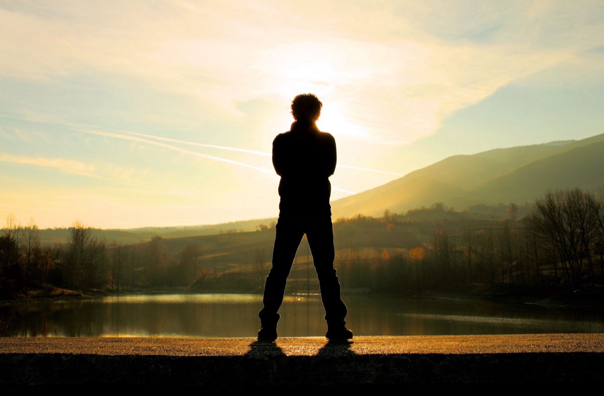 Person standing by a lake at sunset, representing the Whole-Body wellbeing programme